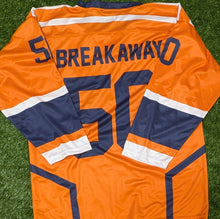 Load image into Gallery viewer, An orange hockey-style jersey laid flat on green artificial turf, showing the back with navy and white stripes, the name BREAKAWAY, and the number 50.
