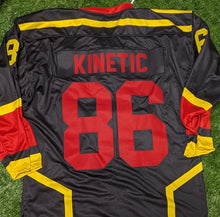 Load image into Gallery viewer, A black athletic jersey laid flat on artificial green turf, featuring the number 98 in red on the back, yellow and red sleeve accents, and the word 'KINETIC' in red across the lower back.
